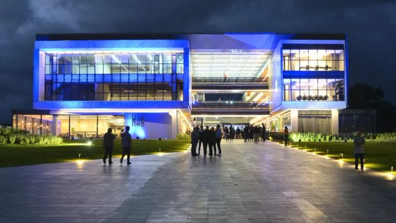 Fachada do Ágora Tech Park iluminada à noite